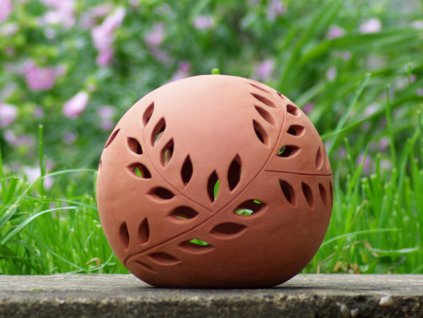 keramicka koule velka cervenice vyrezavanou vetvickou v zahrade