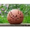 keramicka koule velka cervenice vyrezavanou vetvickou v zahrade