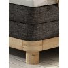 Boxspring posteľ - detail rohu - tmavosivé čalúnenie a masívne drevo