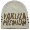 Světle béžová zimní pletená čepice Yakuza Premium 3780W s hnědým nápisem a grafikou lebky s křídly. b