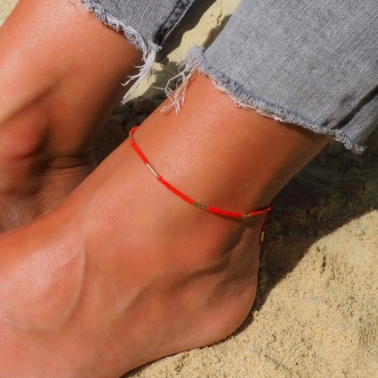 Šňůrkový anklet Red s pozlacenými trubičkami Nufs Design vyfocené na noze