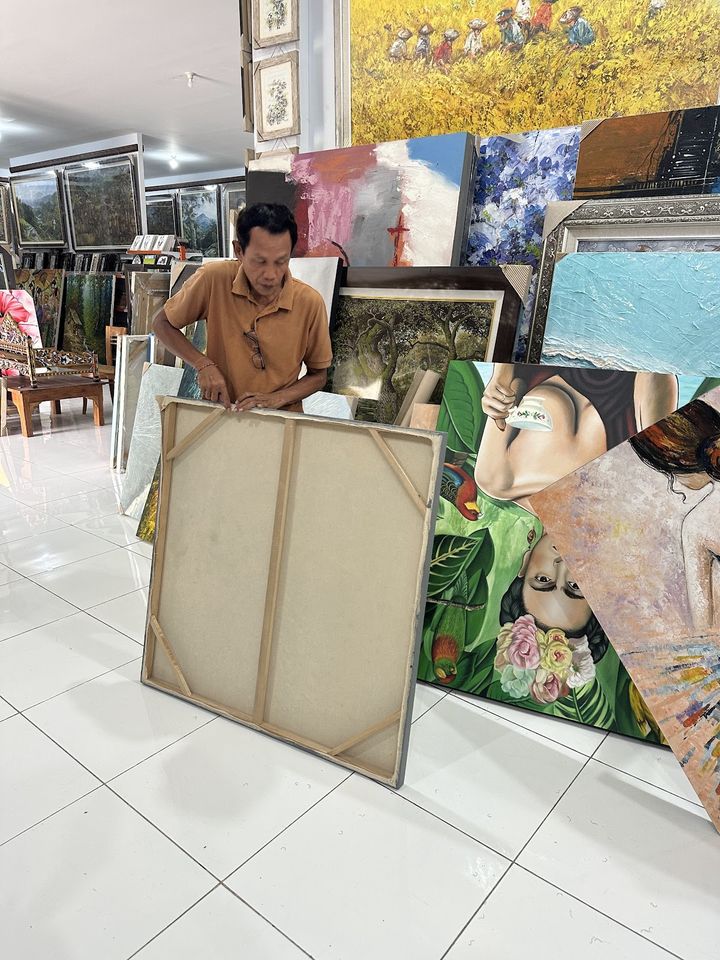Pracovník galerie připravuje velké plátno na balení