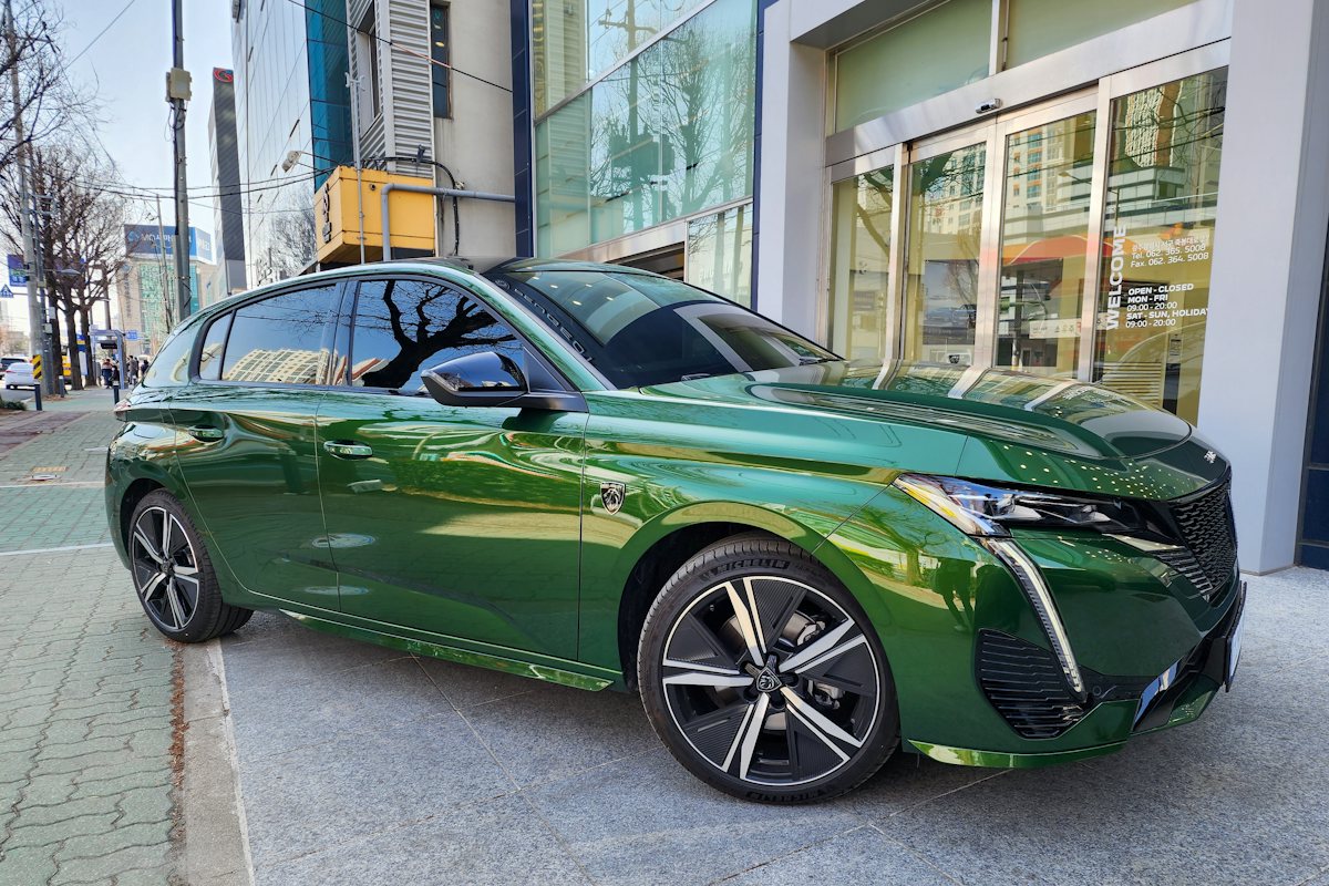 Zelený Peugeot 308 nové generace zaparkovaný u chodníku