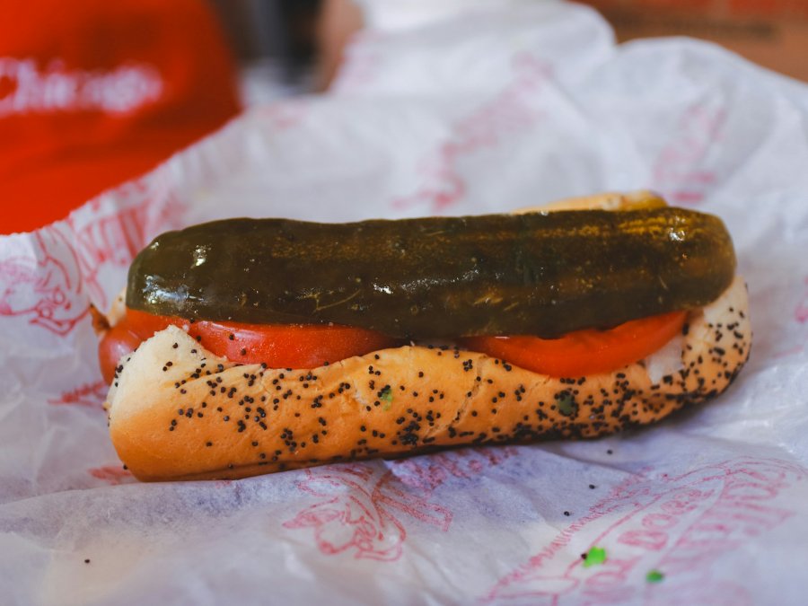 Chicago style hotdog s nakladanou uhorkou, paradajkou a makovým rožkom