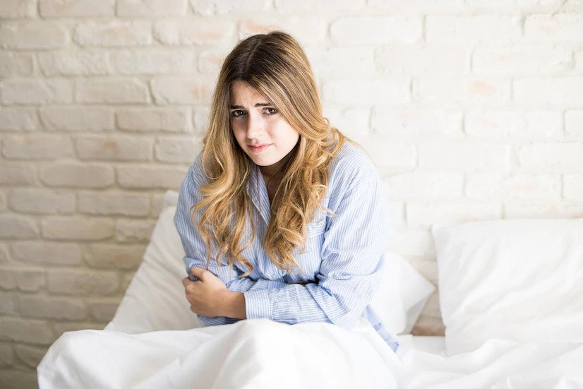 portrait-beautiful-hispanic-young-woman-pajamas-feeling-unwell-with-pms-while-sitting-bed_662251-2430-freepik