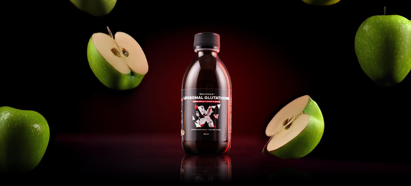 BrainMax Liposomal Glutathione 250 ml – lahvička mezi zelenými jablky na tmavém pozadí