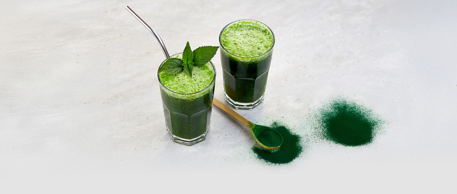 Zelené smoothie s lžící sypkého řasového prášku
