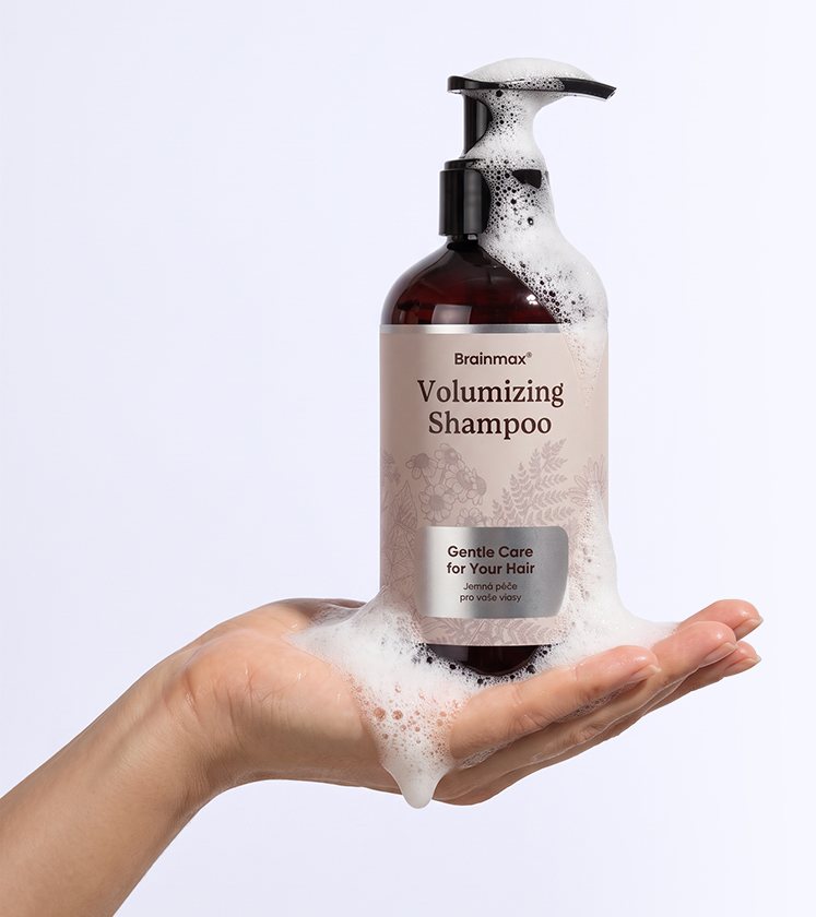 Ruka s lahví Brainmax Volumizing Shampoo a pěnou