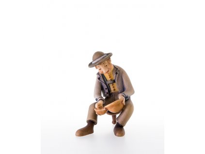 Dřevěná vyřezávaná postava muže, který nalévá mléko ovečkám nebo dalším zvířátkům.