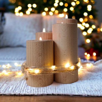 čtyři adventní svíce ze dřeva s různými výškami. svíce jsou omotané světelnou strunou a se zapálenými čajovkami. v pozadí je svítící vánoční strom a bílý kobereček