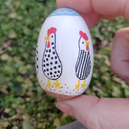 soustružené dřevěné 3D vejce malované bíle s jednoduchou černou kresbou slepiček s červenými hřebínky - v ruce pohledem