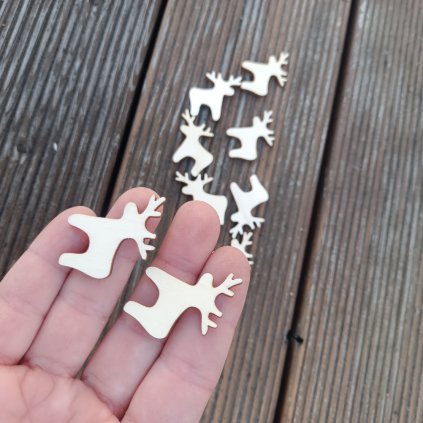 Drobní sobi z překližkového výřezu - dva nadlani, skupina v pozadí na dřevěném podkladu