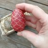dřevěné 3D vejce červené s bíle kreslenými šupinami do podoby šišky - v ruce