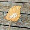 dřevěný ptáček přírodní, lakovaný s bílou kresbou křídla - na dřevěné tyčce