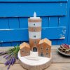 středomořské zátiší  mini vesničky s levandulí a modrými dveřmi v pozadí stylizované - dřevěný maják s čajovou svíčkou a dva bukové rybářské domečky