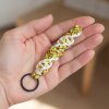 paracord přívěsek DNA žlutobílý dlaň