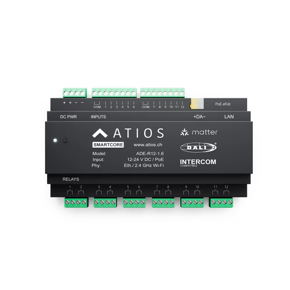 Atios SmartCore ADE-R12 – pohled shora na popsané svorky: napájení DC, vstupy 1–12 se společnými svorkami COM, DALI sběrnice +DA-, PoE af/at, LAN a dole reléové výstupy 1–12