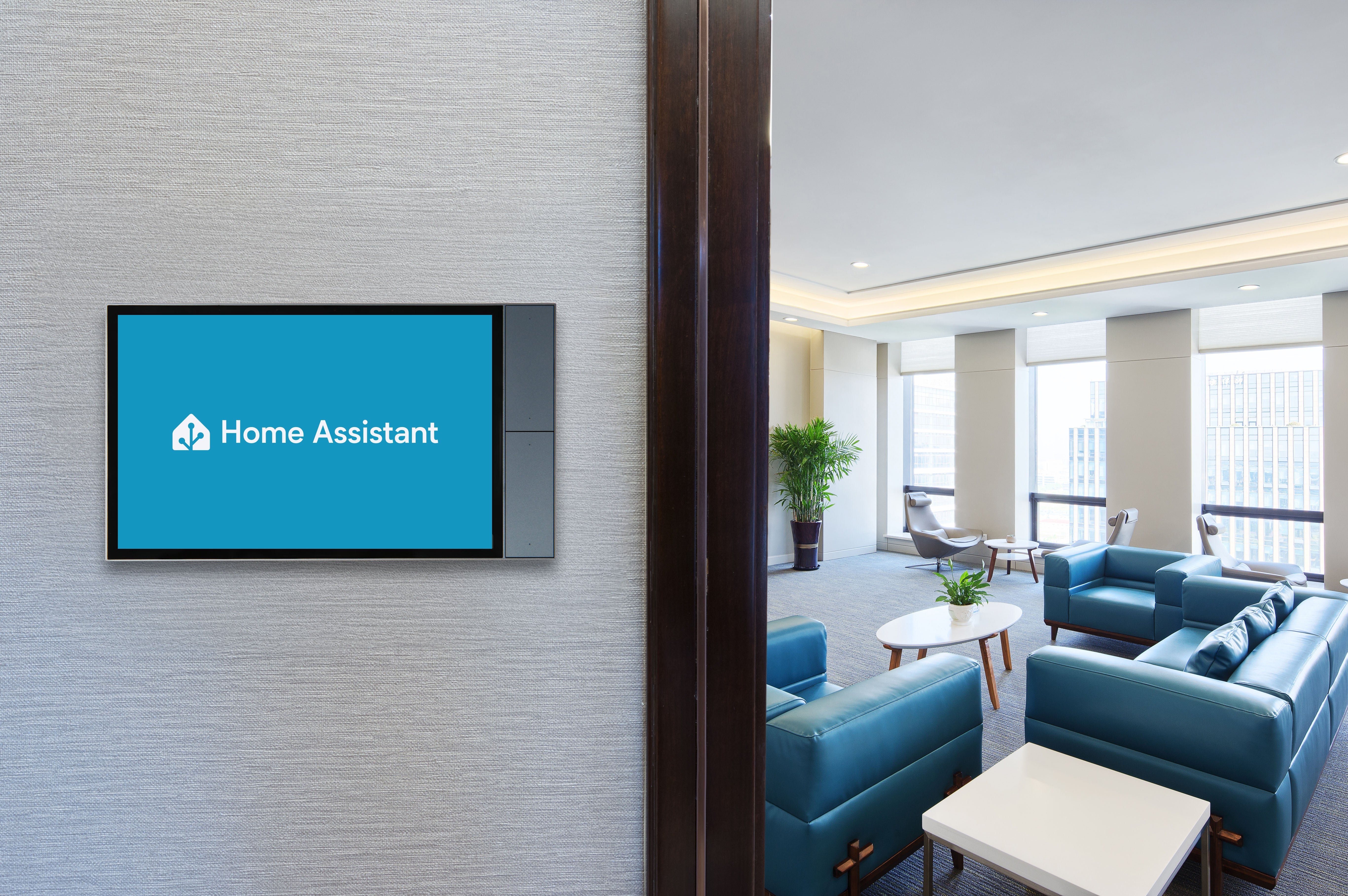 Nástěnný panel Shelly Wall Display XL namontovaný na zdi u vstupu do kancelářské lounge se zobrazenou úvodní obrazovkou Home Assistant