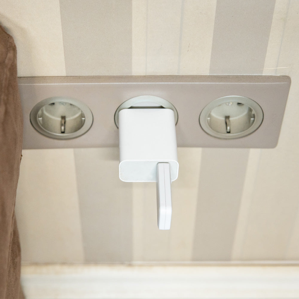 Brána v podobě USB donglu zasunutá do napájecího adaptéru v zásuvce