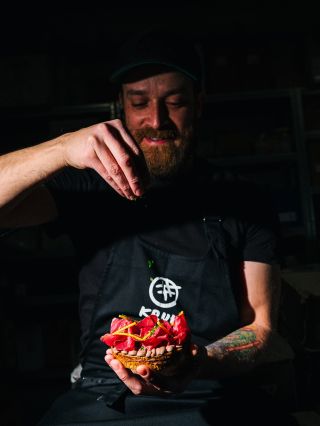 Krajec integrale chlebu ako pevný základ. Na ňom krém z čiernych fazúľ a fermentovaného čierneho cesnaku, zjemnený tahini...