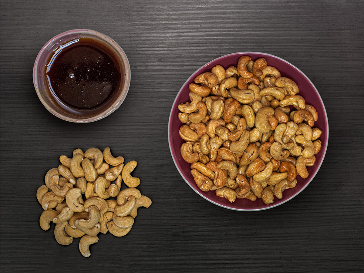 Kešu a javorový sirup — jediné dve suroviny, flatlay na tmavom dreve