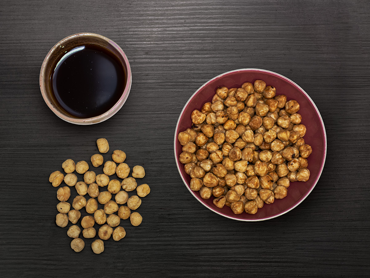 Lieskovce a javorový sirup — flatlay na tmavom dreve