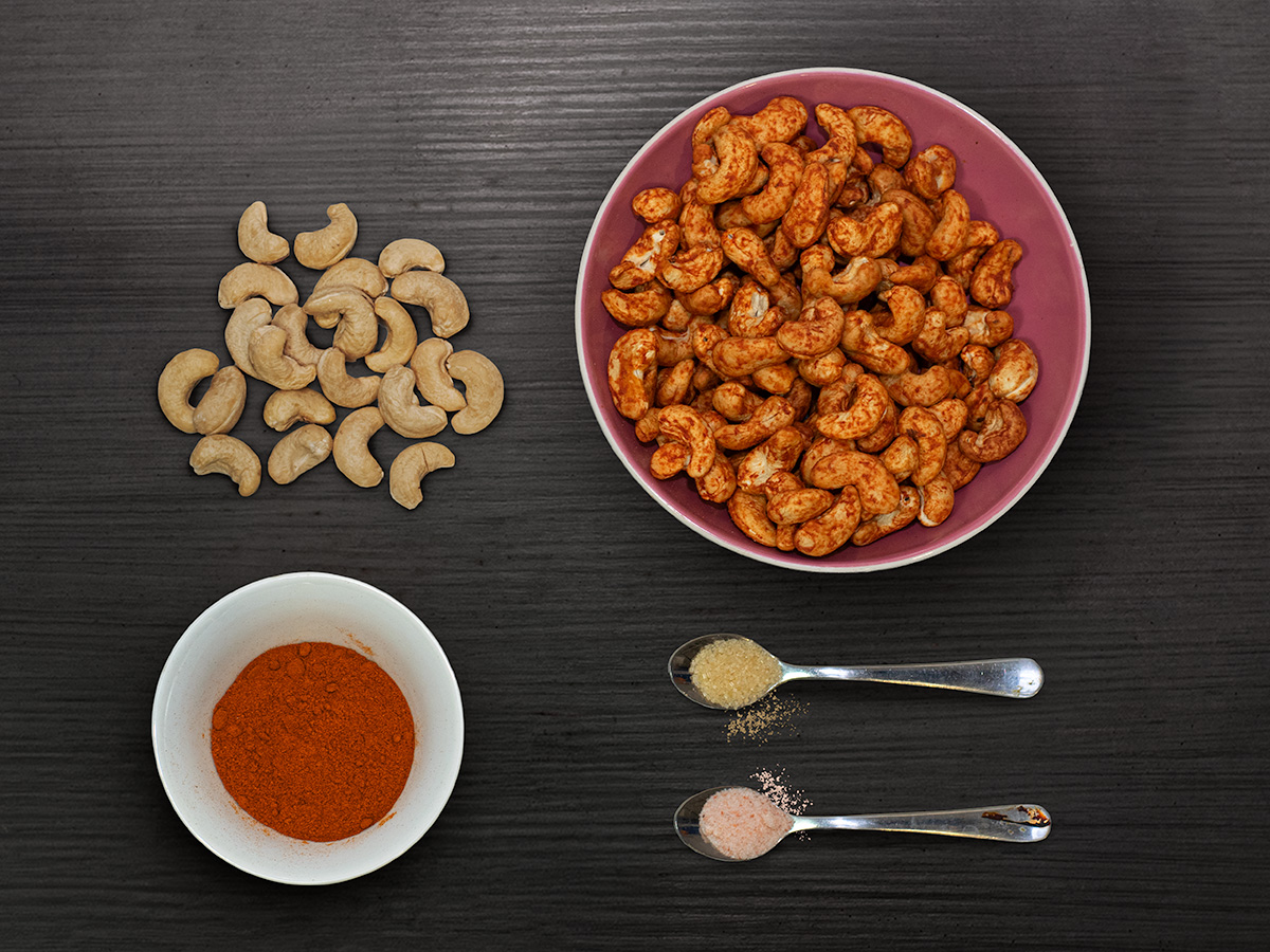 Paprikové kešu a údená paprika — flatlay na tmavom dreve
