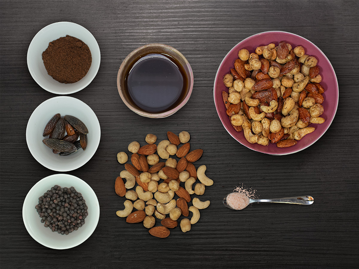 Mix orechov s vanilkou a tonka fazuľkou — flatlay na tmavom dreve
