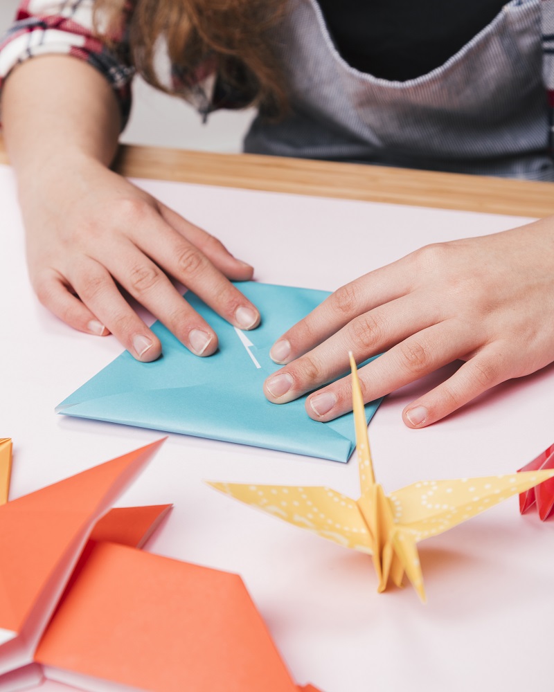 close-up-woman-hand-folding-origami-paper-making-creative-craft