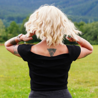  Krátká blond vlnitá paruka s ofinou ze syntetických vlasů.