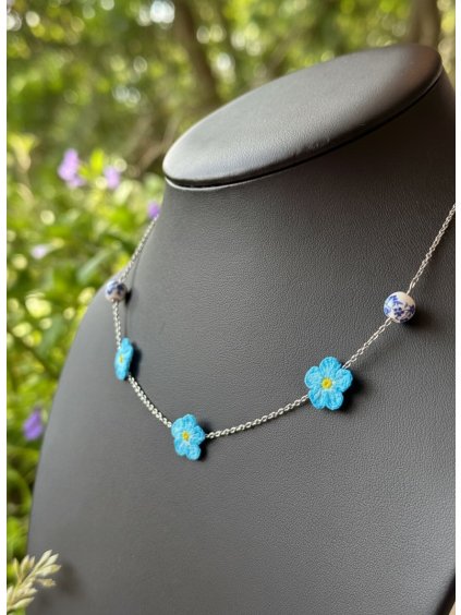 Náhrdelník Pomněnky – nezapomeň na krásu okamžiku  Náhrdelník Pomněnky jsem tvořila s myšlenkou na jemný talisman, který bude připomínat, že ty nejkrásnější chvíle v životě stojí za to si uchovat v srdci. Každý drobný modrý květ je ručně háčkovaný technikou micro crochet, s citem pro detail a lehkost. Kvítky jsou poskládané tak, aby působily jako živý hrozen pomněnek – něžný, hravý a autentický.