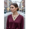 Styling tip: Noste náhrdelník nad tmavě zeleným rolákem nebo burgundy halenkou a nechte ho spočinout přesně na úrovni srdce. Zkombinujte ho s jednoduchými zlatými náušnicemi a vlasy si upravte do elegantního nízkého drdolu s několika volnými pramínky. Tento styling vytvoří dokonalou harmonii mezi ochrannou symbolikou cesmíny a vaší sofistikovanou elegancí - budete vypadat jako žena, která zná svou sílu a nosí ji s grácií.