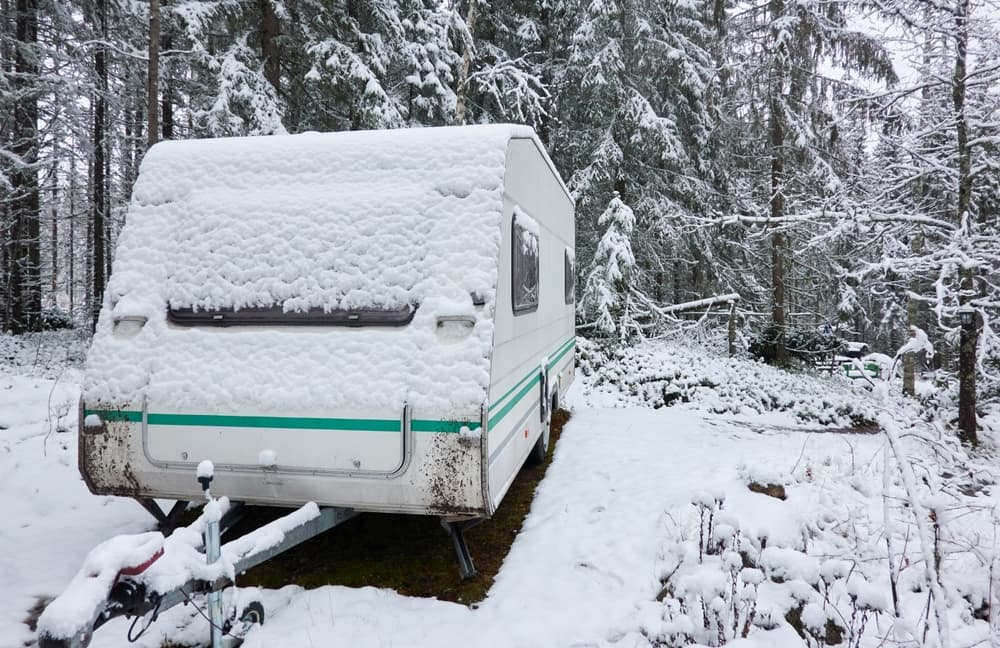 Zasněžený karavan v lese