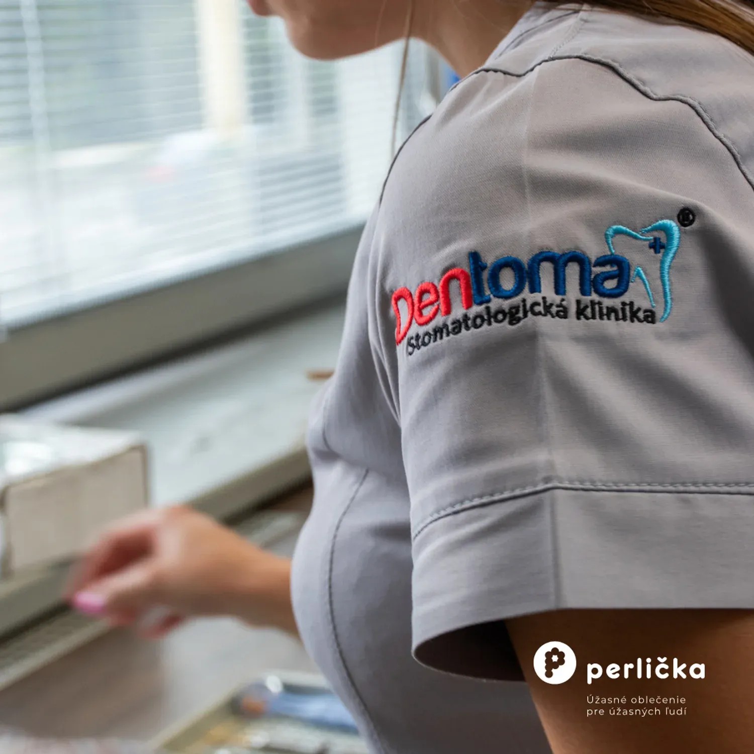 Vyšité logo stomatologickej kliniky na zdravotníckom oblečení Perlička