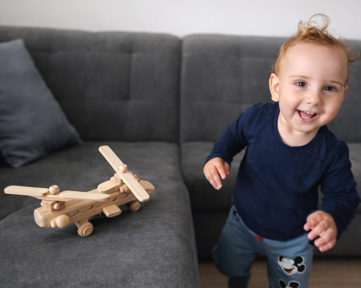 štastné dítě si hraje s masivním dřevěným kargo vrtulníkem
