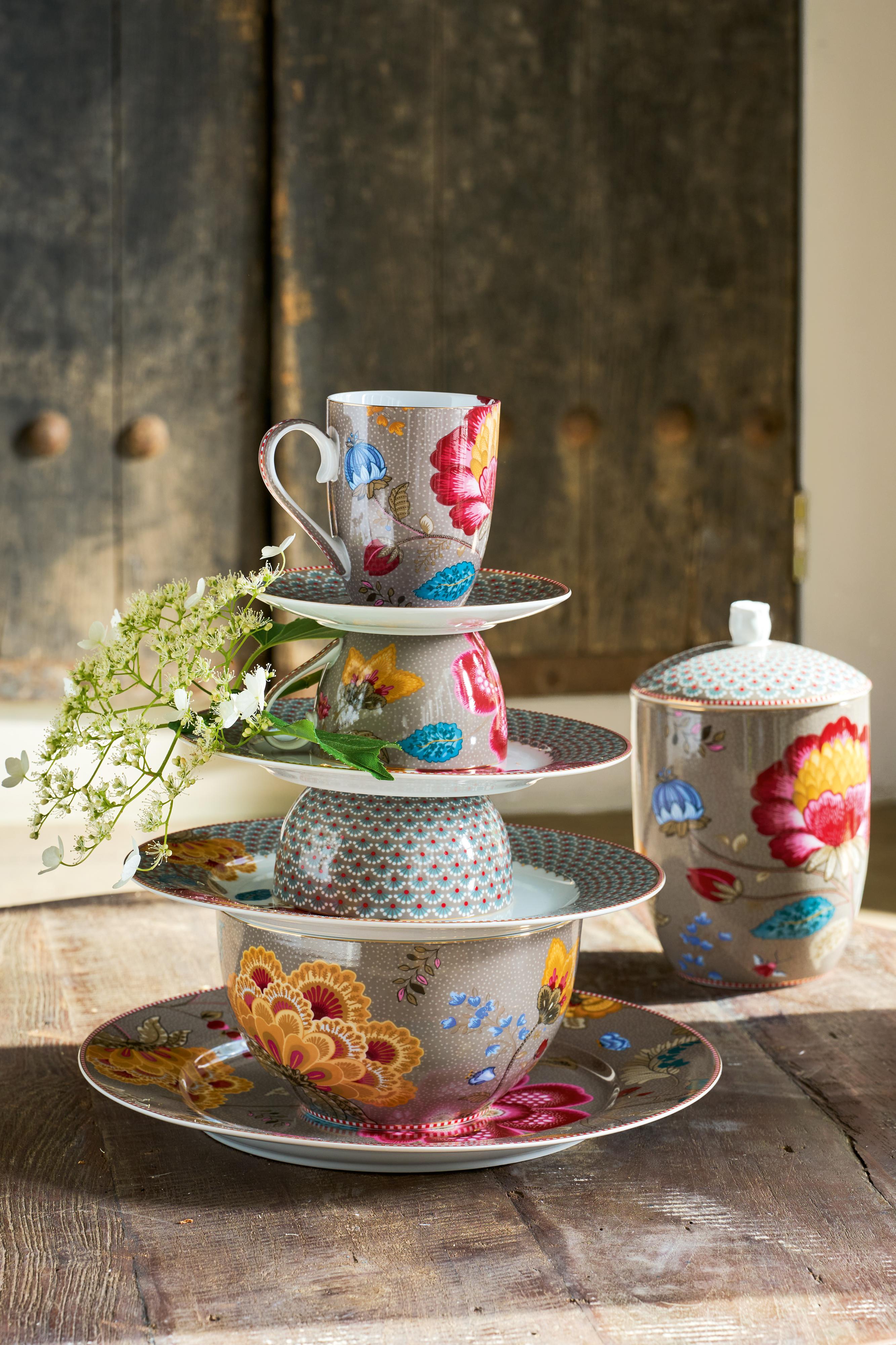 Porcelánový šálek na cappuccino s podšálkem z kolekce Pip Studio Blooming Tales Khaki jako pyramida z talíře, misky , hrnku na dřevěném stole.
