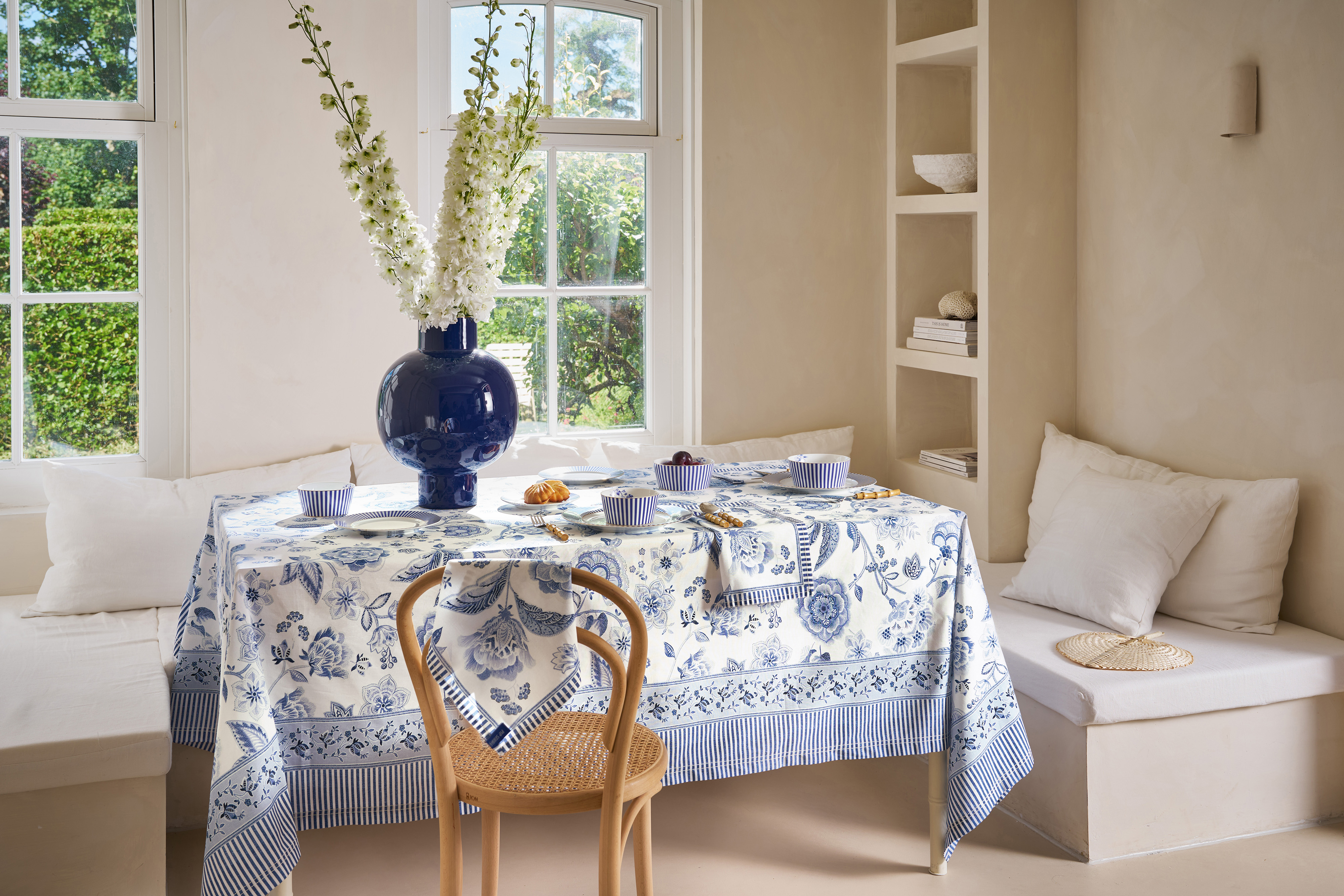 Modrobílý bavlněný ubrus s velkými květy a porcelán Pip Studio Royal na prostřeném stole u okna