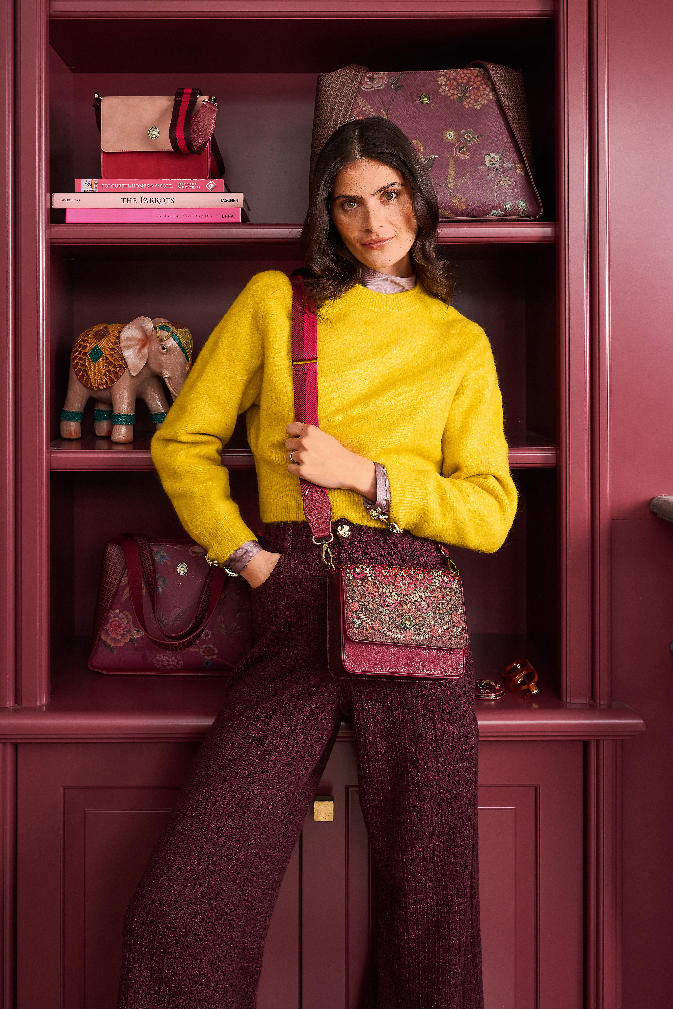 Vínová dámská crossbody kabelka Pip Studio Fenna Il Ricamo s nastavitelným popruhem na modelce ve žlutém svetru