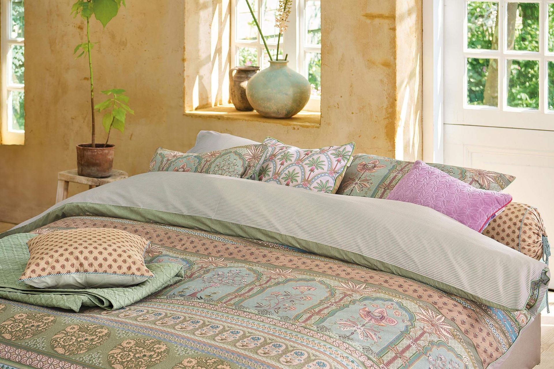 Pip Studio perkálové povlečení Bollywood Dreams zelené ustlaná postel  a barevné polštáře s květinami