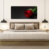 Moderný doplnok do spálne, bezrámový obraz ruže v živých farbách nad posteľou