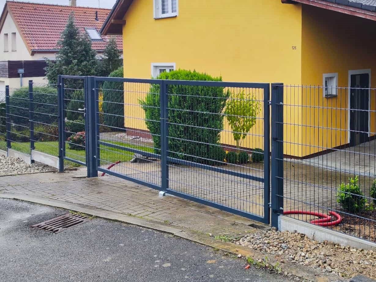 Antracitová dvojkrídlová brána s výplňou z 2D panelov pred rodinným domom