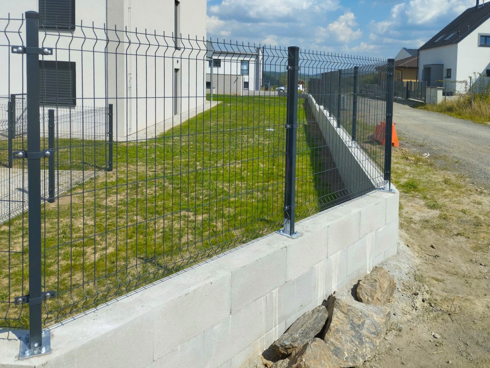 Antracitové 3D plotové panely so stĺpikmi ukotvenými pätkami na podmurovke