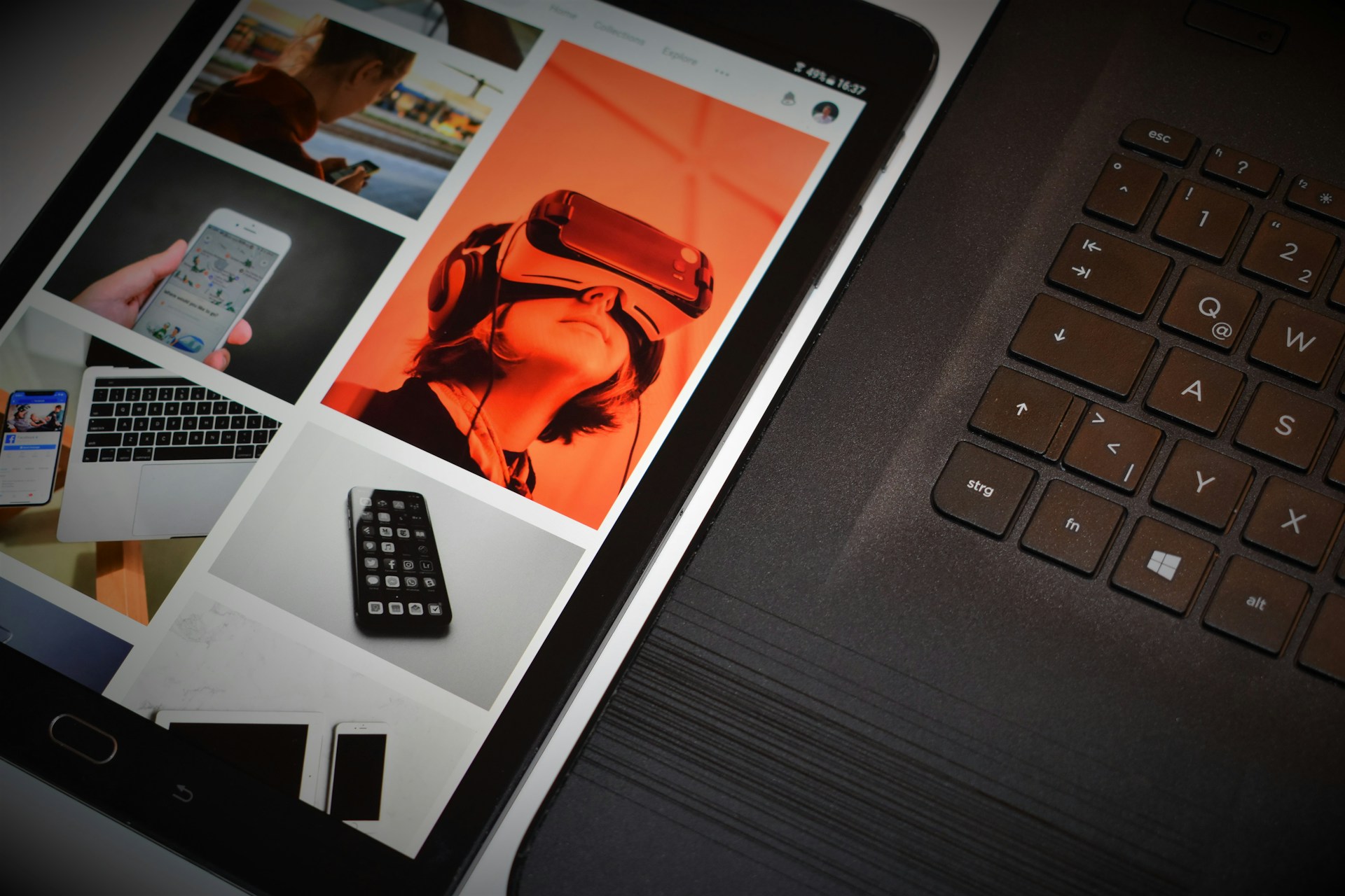 Tablet s otvoreným obrazovým obsahom položený pri klávesnici notebooku.