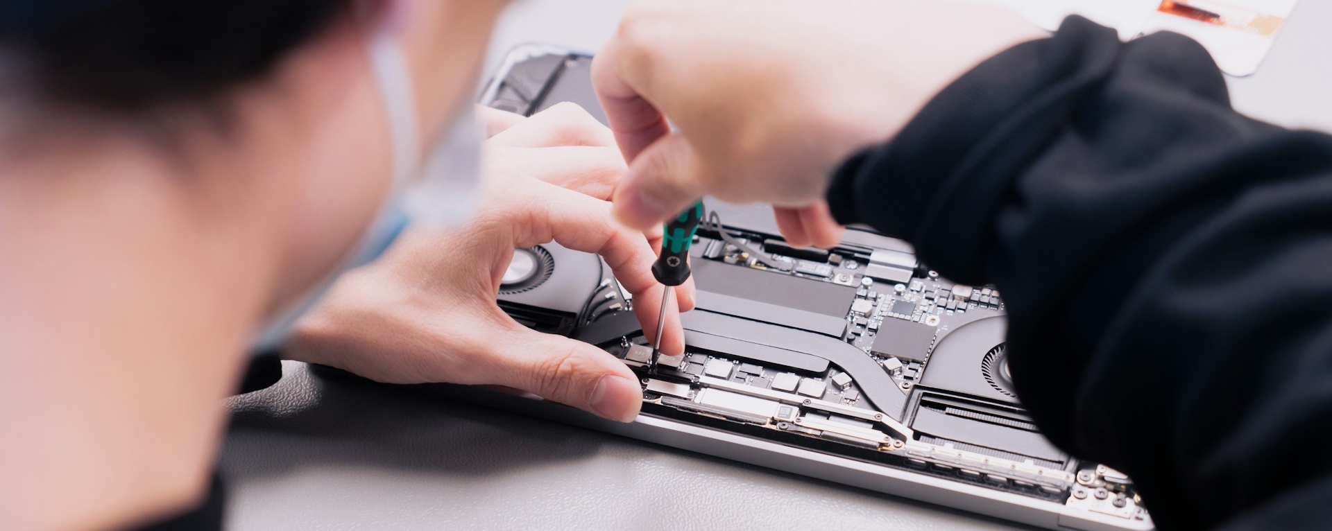 Technik pri rozobratom notebooku počas servisného zásahu