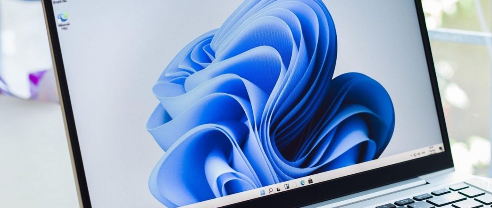 Notebook so systémom Windows 11 na svetlom pracovnom stole