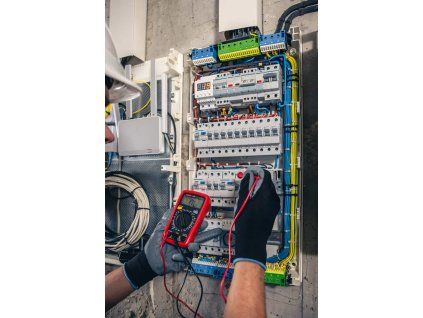 man electrical technician working switchboard with fuses scaled