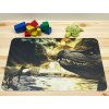 PVC prostírání na stůl s realistickým motivem prehistorické krajiny, sopka s lávou a dva dinosauři u vodní hladiny, výrazný kontrast tmavých skal a zlatého světla