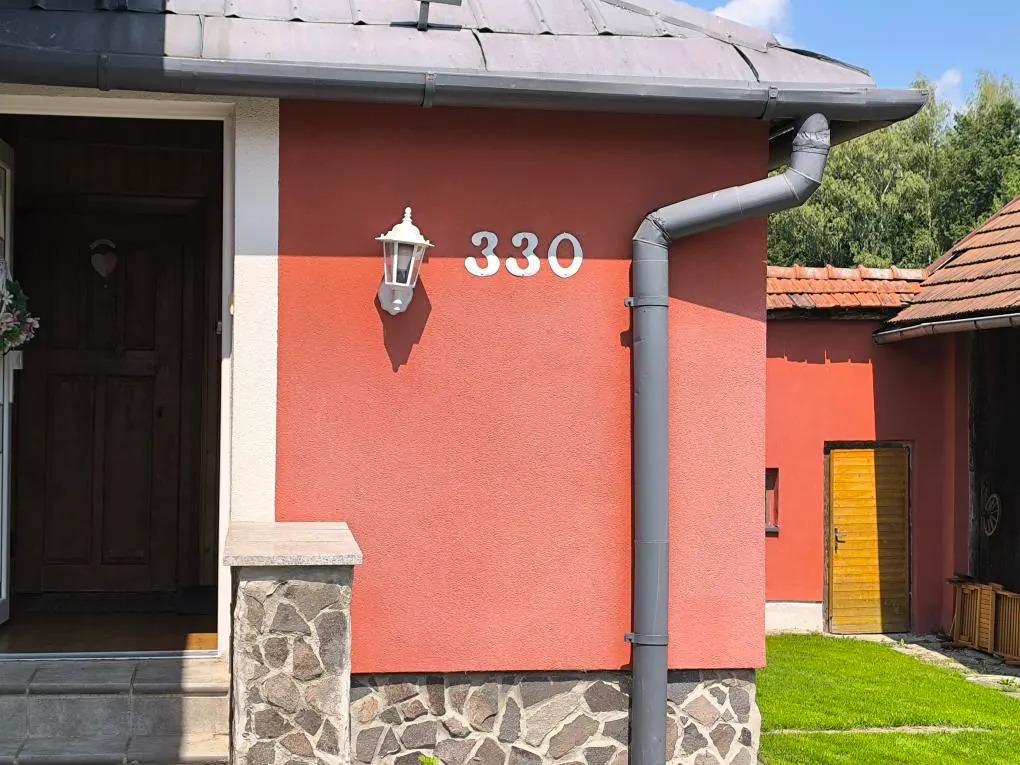Červená fasáda u vstupu a pod přesahem střechy