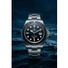 Product Shot Silver and black watch with water droplets on surface dark blue ocean background dr