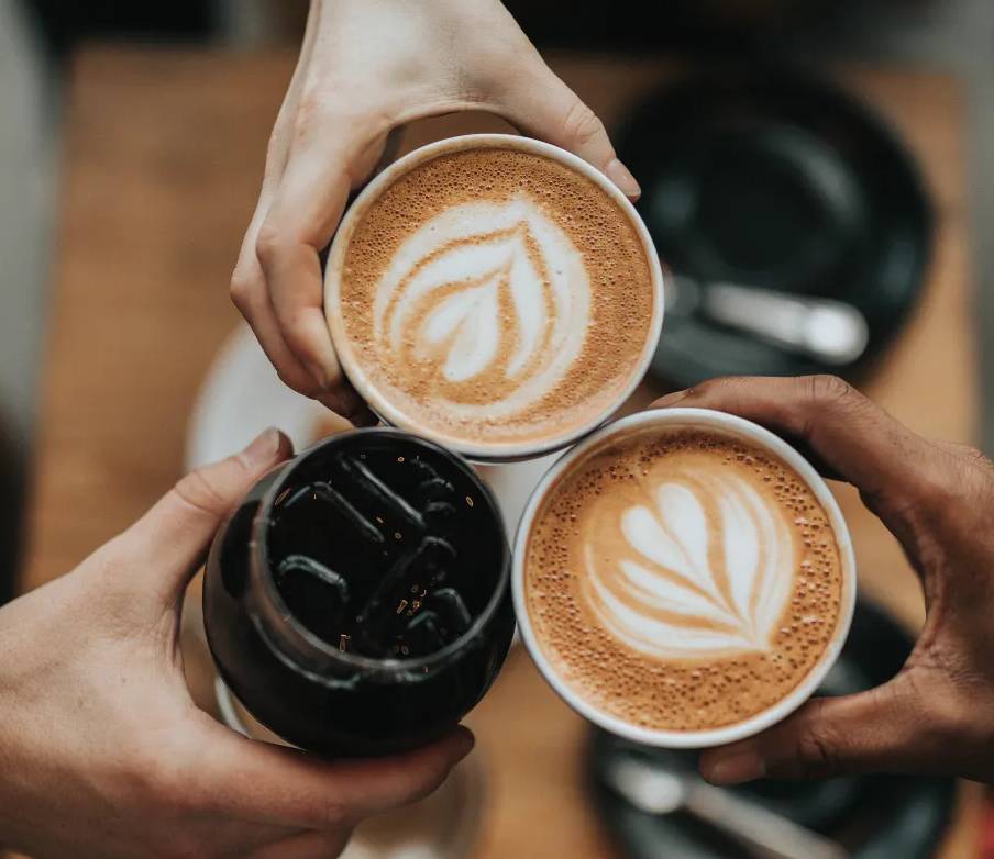 ruce, které drží šálky kávy